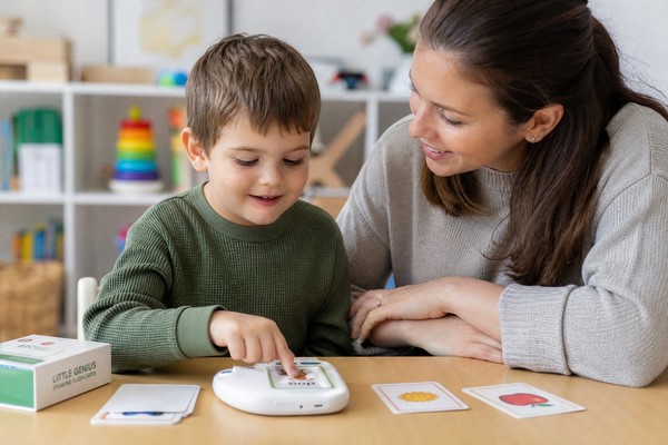 Child using talking flash cards with therapist
